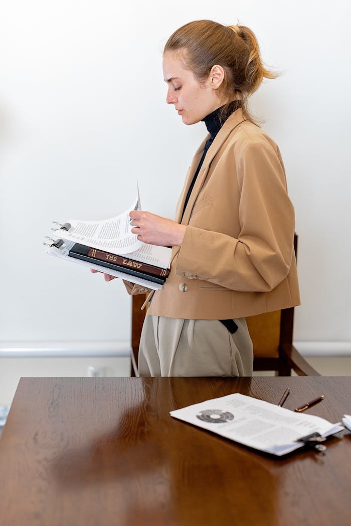 Woman lawyer reviewing papers at office desk, focused and professional.